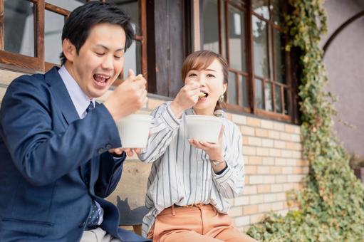 屋外で楽しそうに食事をする男女の写真。食を楽しみながら健康的に過ごす秋のイメージ。