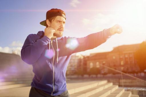朝日に向かって構える男性。活力と集中力を取り戻し、行動を起こすエネルギーを象徴するイメージ。