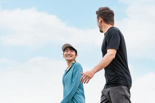 晴天の下でウォーキングを楽しむ男女。風邪をひかない健康的な日常を象徴。