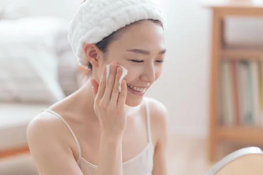 コットンで肌のケアをする女性。やさしく保湿する様子