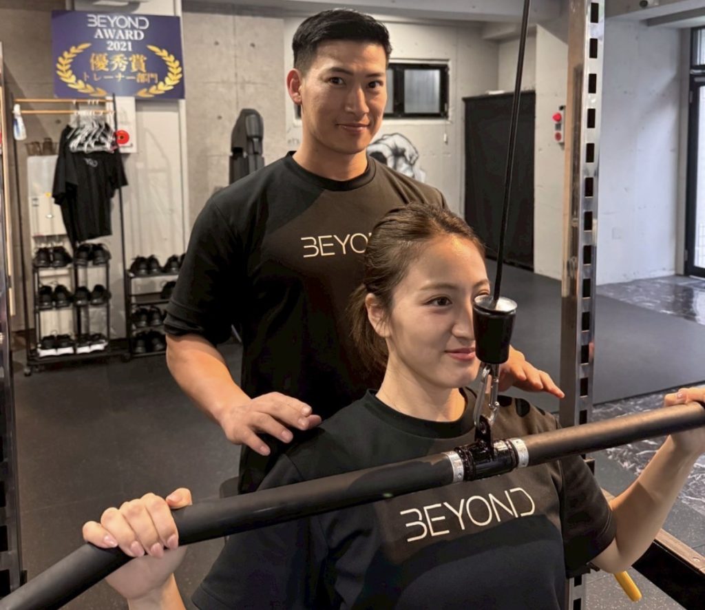 BEYOND武蔵小杉のトレーナーが女性に正しいフォームを指導している様子