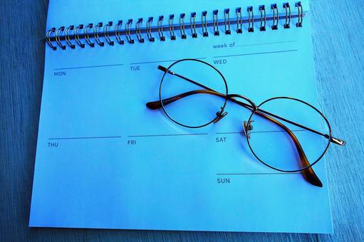 「生活習慣やルーティン管理のための週間スケジュール帳とメガネ」