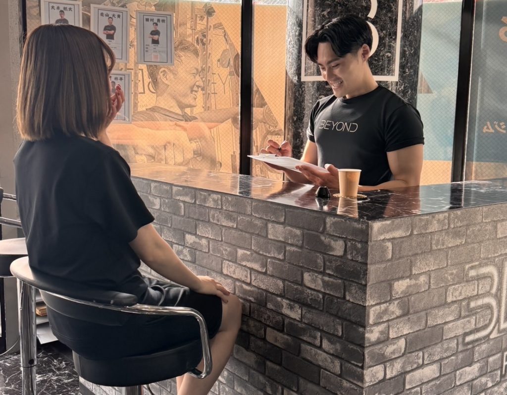 BEYOND武蔵小杉店でトレーナーとカウンセリングを行う女性