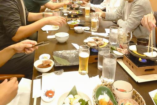 居酒屋で多くの料理とお酒が並ぶテーブル