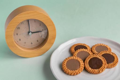「お菓子と時計が並び、間食の時間を示している写真」
