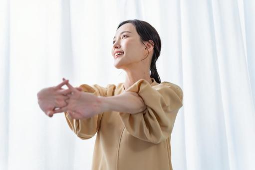 室内で気持ちよくストレッチをする女性