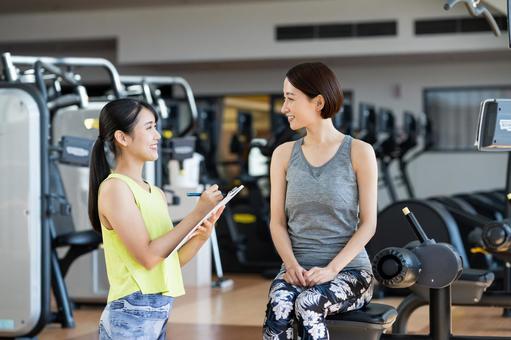 パーソナルトレーナーに食事相談をしている女性